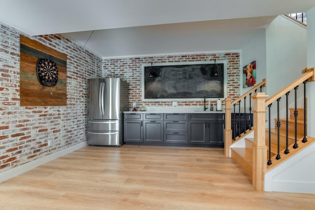E12785 Wynding Way, Merrimac, WI 53561 - bar with freestanding refrigerator, light wood finished floors, stairs, a sink, and brick wall