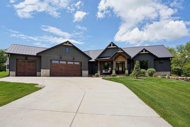 E12785 Wynding Way, Merrimac, WI 53561 - view of front of home featuring an attached garage, a front yard, driveway, stone siding, and metal roof