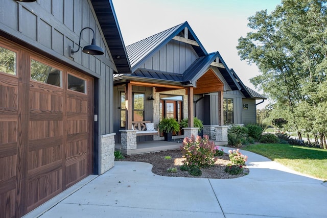 E12785 Wynding Way, Merrimac, WI 53561 - view of exterior entry featuring board and batten siding, a standing seam roof, metal roof, stone siding, and driveway