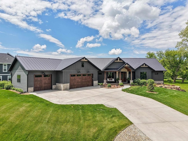 E12785 Wynding Way, Merrimac, WI 53561 - view of front of house featuring a garage, driveway, a front lawn, board and batten siding, and metal roof