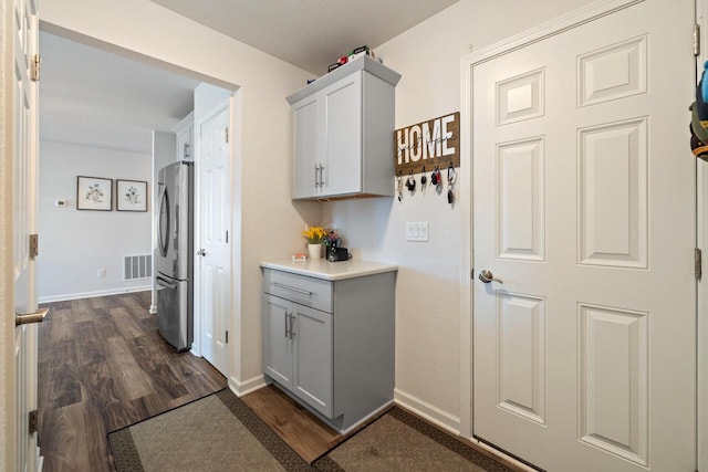 35209 Winnebago Ct, Summit, WI 53066 - laundry area with dark wood-type flooring, cabinet space, and baseboards