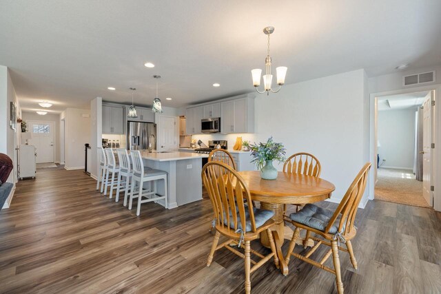 35209 Winnebago Ct, Summit, WI 53066 - dining space featuring dark wood-style floors, baseboards, recessed lighting, and a chandelier