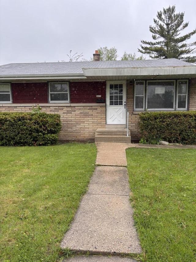 9610 W Lisbon Ave, Milwaukee, WI 53222 - ranch-style home with a front lawn, a chimney, and brick siding