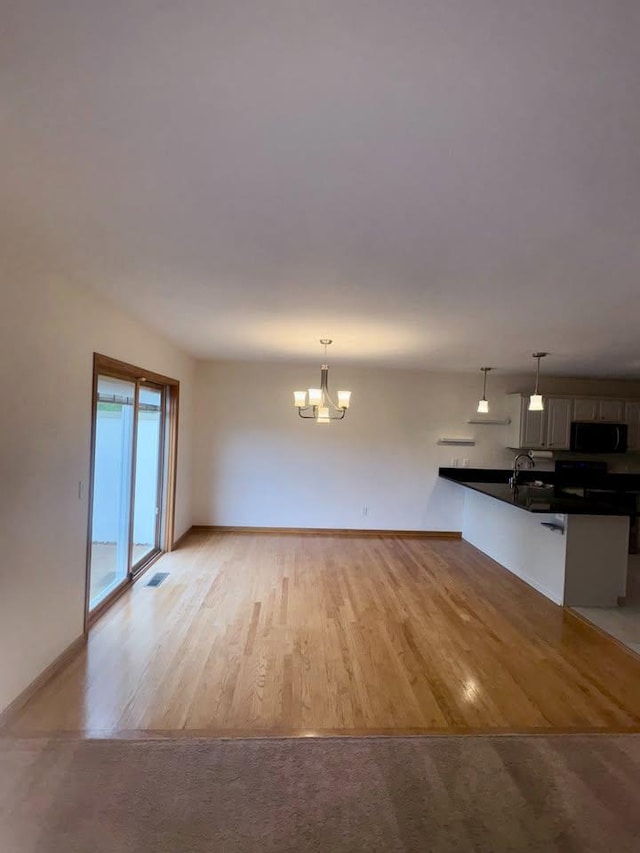 27 Waterford Cir, Madison, WI 53719 - unfurnished living room featuring a chandelier and light wood finished floors