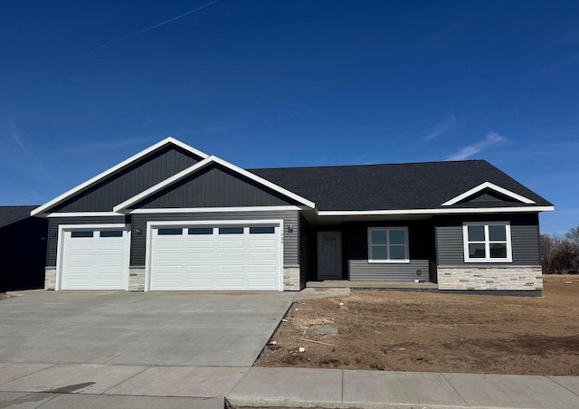 2214 Sierra Ave, Holmen, WI 54636 - view of front of property featuring stone siding, a garage, concrete driveway, and a shingled roof