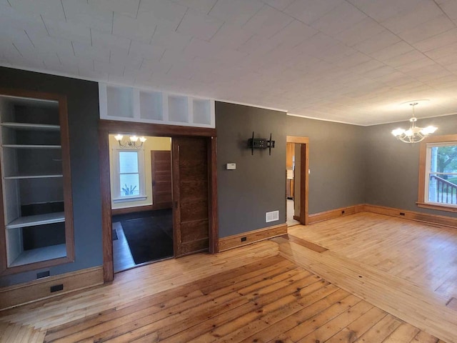 324 N Pine St, Reedsburg, WI 53959 - spare room featuring a chandelier, wood-type flooring, baseboards, and a fireplace