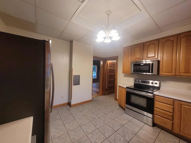 324 N Pine St, Reedsburg, WI 53959 - kitchen with stainless steel appliances, a chandelier, light countertops, brown cabinets, and light tile patterned floors