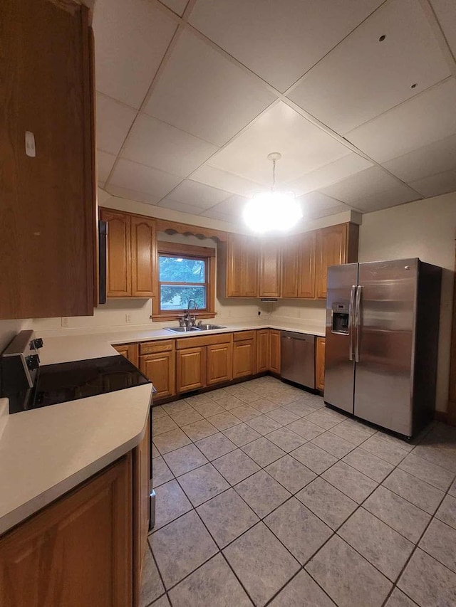 324 N Pine St, Reedsburg, WI 53959 - kitchen featuring appliances with stainless steel finishes, a sink, light tile patterned floors, light countertops, and brown cabinetry