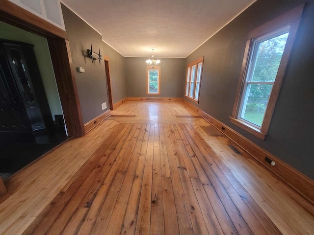 324 N Pine St, Reedsburg, WI 53959 - unfurnished room featuring a chandelier, hardwood / wood-style flooring, ornamental molding, and baseboards