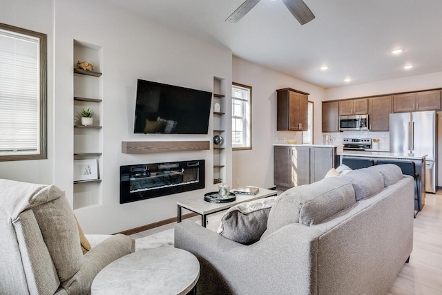 1325 Hagar St, La Crosse, WI 54603 - living room with a ceiling fan, built in features, light wood-style flooring, recessed lighting, and a glass covered fireplace
