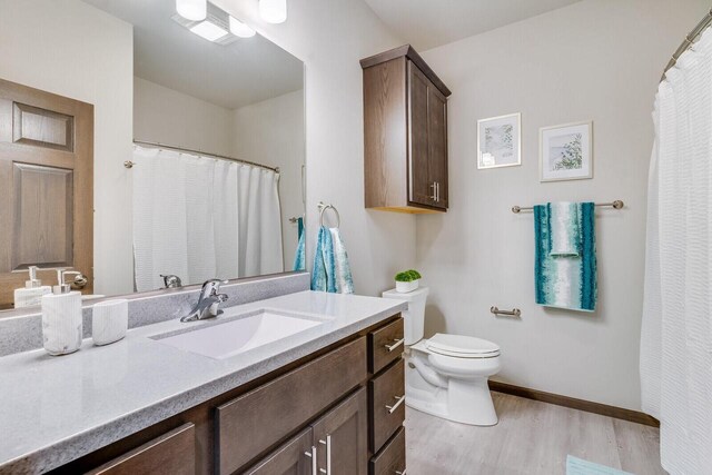 1325 Hagar St, La Crosse, WI 54603 - bathroom featuring vanity, wood finished floors, toilet, baseboards, and a shower with shower curtain