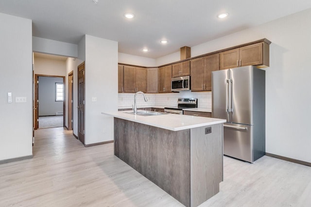1325 Hagar St, La Crosse, WI 54603 - kitchen with appliances with stainless steel finishes, a sink, light wood finished floors, decorative backsplash, and recessed lighting