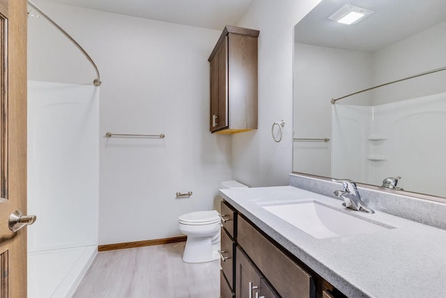 1325 Hagar St, La Crosse, WI 54603 - bathroom featuring a shower, wood finished floors, vanity, toilet, and baseboards