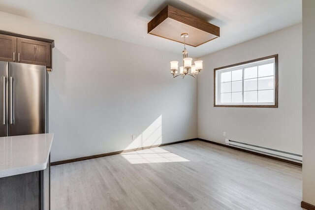 1325 Hagar St, La Crosse, WI 54603 - unfurnished dining area with a baseboard radiator, light wood-style flooring, a chandelier, and baseboards