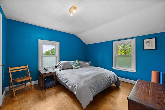841 4th St S, Wisconsin Rapids, WI 54494 - bedroom with baseboards, hardwood / wood-style floors, lofted ceiling, and multiple windows