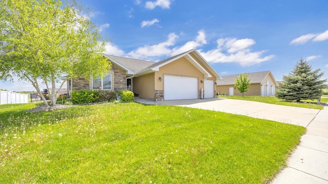 323 Autumn Ln, Campbellsport, WI 53010 - ranch-style home with stone siding, an attached garage, driveway, and a front lawn