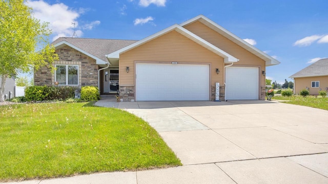 323 Autumn Ln, Campbellsport, WI 53010 - view of front of property with stone siding, a garage, concrete driveway, and a front lawn