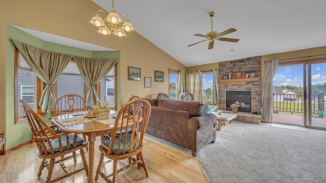 323 Autumn Ln, Campbellsport, WI 53010 - dining space with a ceiling fan, a chandelier, high vaulted ceiling, a stone fireplace, and light wood finished floors