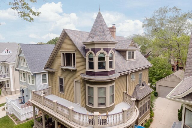 2710 N Hackett Ave, Milwaukee, WI 53211 - rear view of house featuring a chimney, a shingled roof, a deck, an outdoor structure, and a garage