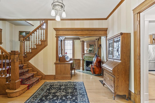 2710 N Hackett Ave, Milwaukee, WI 53211 - foyer entrance with wood finished floors, stairs, a fireplace, wallpapered walls, and crown molding