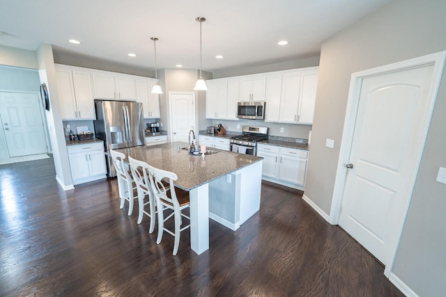 7236 N Beau Ave, Milwaukee, WI 53224 - kitchen with stainless steel appliances, dark wood-type flooring, a breakfast bar area, an island with sink, and white cabinets