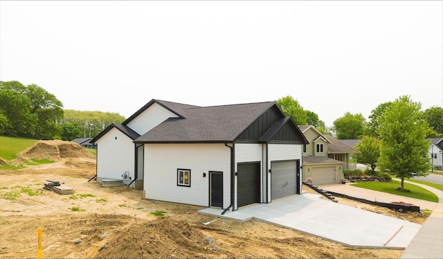 935 Hay Creek Trl, Reedsburg, WI 53959 - view of side of home with board and batten siding, an attached garage, and concrete driveway
