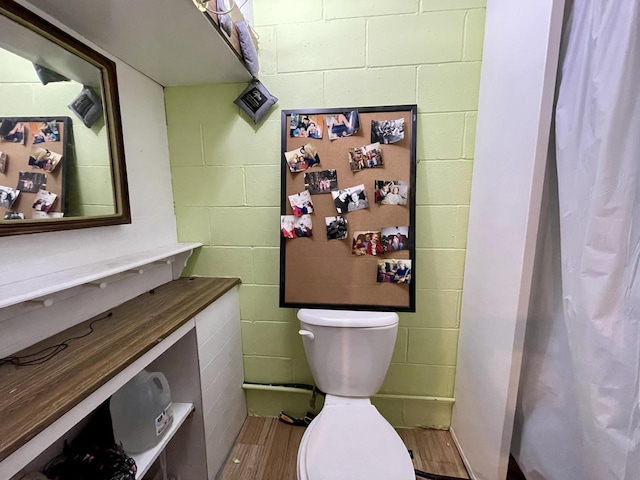 1522 Barlow St, La Crosse, WI 54601 - full bath with toilet, curtained shower, concrete block wall, wood finished floors, and vanity