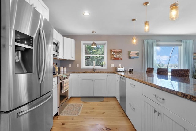 1014 Long Bow Ct, Nekoosa, WI 54457 - kitchen with appliances with stainless steel finishes, light wood-type flooring, stone counters, a sink, and white cabinetry