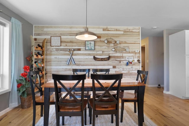 1014 Long Bow Ct, Nekoosa, WI 54457 - dining room with wood walls, an accent wall, baseboards, and light wood-style floors