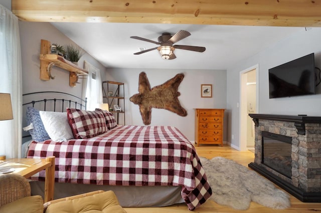 1014 Long Bow Ct, Nekoosa, WI 54457 - bedroom with light wood-style floors, a fireplace, and ceiling fan
