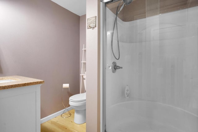 1014 Long Bow Ct, Nekoosa, WI 54457 - bathroom featuring toilet, vanity, wood finished floors, baseboards, and shower / bathtub combination