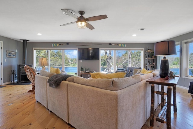 1014 Long Bow Ct, Nekoosa, WI 54457 - living area featuring a wood stove, light wood-style flooring, healthy amount of natural light, recessed lighting, and ceiling fan