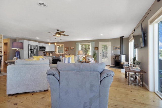 1014 Long Bow Ct, Nekoosa, WI 54457 - living area with a wood stove, light wood-type flooring, ceiling fan, and recessed lighting