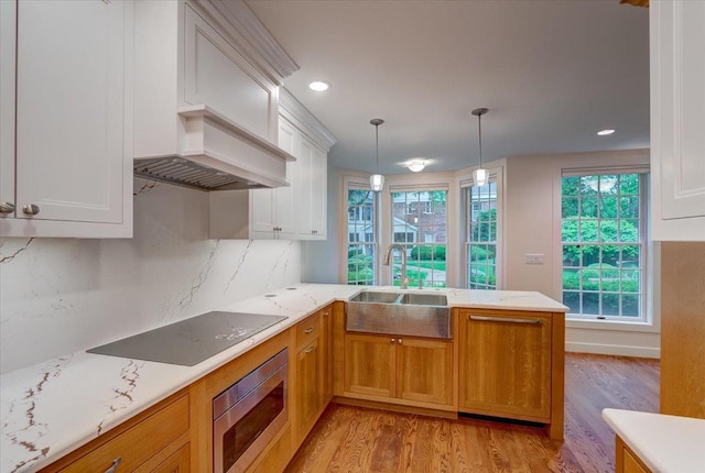 2818 Marshall Ct, Madison, WI 53705 - kitchen featuring a sink, black electric cooktop, light wood-style floors, a peninsula, and recessed lighting