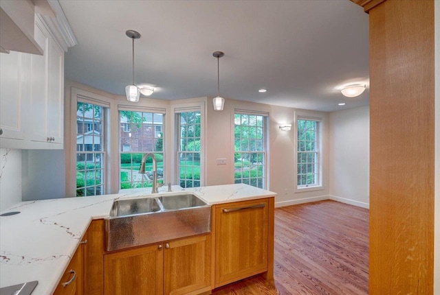 2818 Marshall Ct, Madison, WI 53705 - kitchen with a sink, light wood-style floors, brown cabinets, and light stone countertops