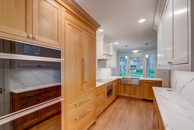 2818 Marshall Ct, Madison, WI 53705 - kitchen with a sink, wall oven, black electric stovetop, light wood-type flooring, and decorative backsplash