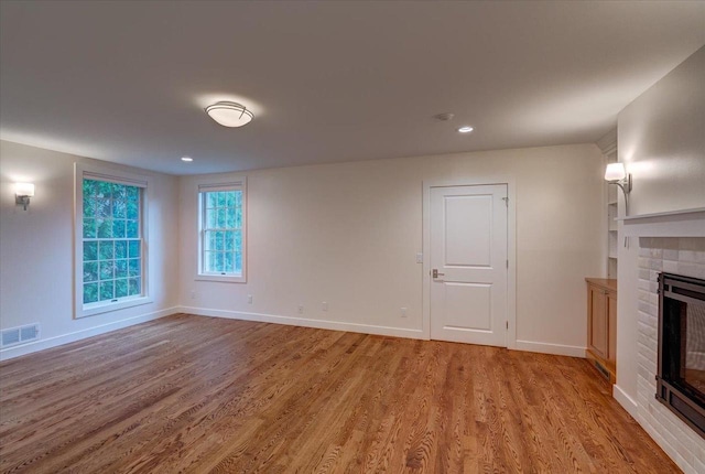 2818 Marshall Ct, Madison, WI 53705 - unfurnished living room with light wood-style floors, a glass covered fireplace, baseboards, and recessed lighting