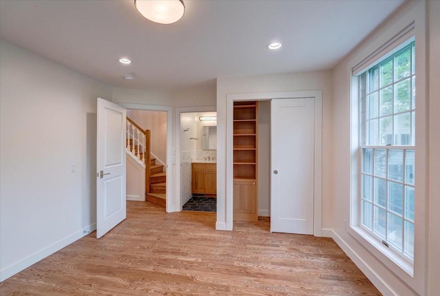 2818 Marshall Ct, Madison, WI 53705 - unfurnished bedroom with light wood-style floors, a closet, recessed lighting, ensuite bathroom, and baseboards