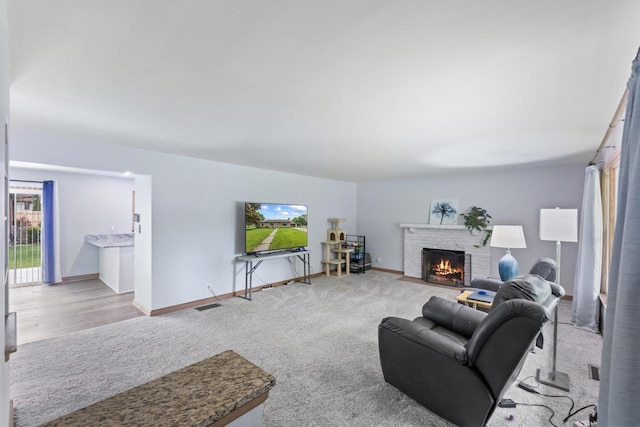 519 S Charles St, Waukesha, WI 53186 - carpeted living room featuring a brick fireplace and baseboards