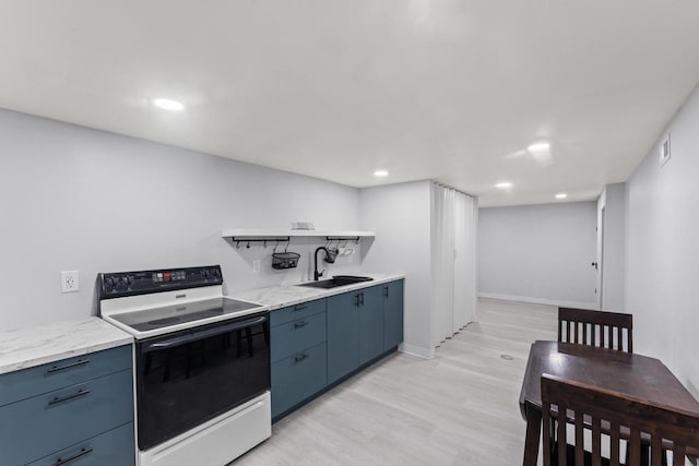 519 S Charles St, Waukesha, WI 53186 - kitchen featuring range with electric cooktop, a sink, open shelves, blue cabinetry, and light wood finished floors