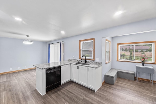 519 S Charles St, Waukesha, WI 53186 - kitchen featuring black dishwasher, a peninsula, white cabinetry, a sink, and light stone counters