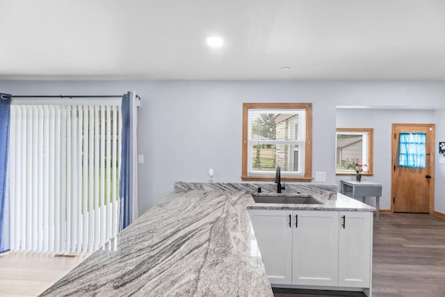 519 S Charles St, Waukesha, WI 53186 - kitchen with a sink, white cabinetry, light stone countertops, wood finished floors, and recessed lighting