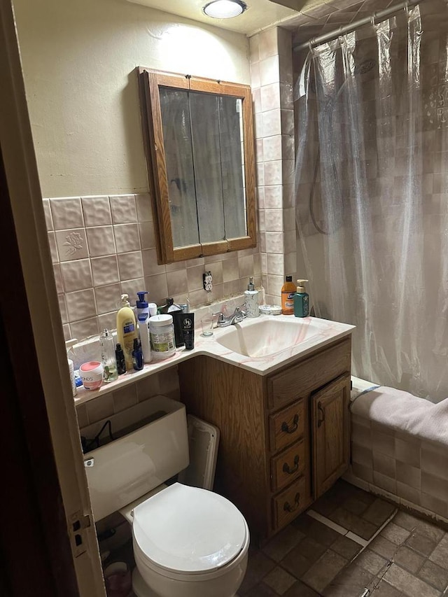 3747 N Vel R Phillips Ave, Milwaukee, WI 53212 - full bath featuring toilet, vanity, shower / bathtub combination with curtain, tile walls, and stone finish flooring