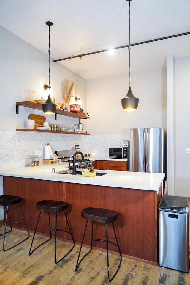 1017 S 2nd St Unit 302, Milwaukee, WI 53204 - kitchen with light wood finished floors, freestanding refrigerator, open shelves, and backsplash