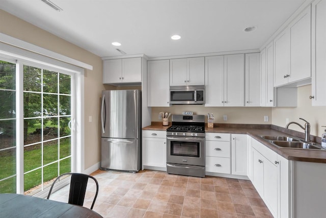 3155 W Lake Helen Dr, Rosholt, WI 54473 - kitchen featuring stainless steel appliances, a sink, dark countertops, white cabinets, and recessed lighting