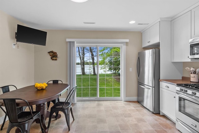3155 W Lake Helen Dr, Rosholt, WI 54473 - kitchen with appliances with stainless steel finishes, white cabinets, baseboards, and recessed lighting