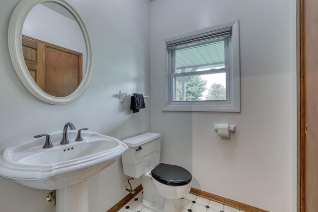 W1041 County Road O, Oconomowoc, WI 53066 - bathroom featuring toilet, baseboards, and a sink