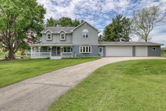W1041 County Road O, Oconomowoc, WI 53066 - view of front of property featuring a porch, driveway, a front yard, and a garage