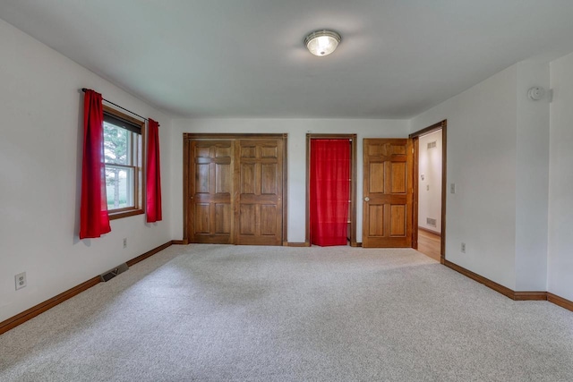 W1041 County Road O, Oconomowoc, WI 53066 - unfurnished bedroom featuring carpet, baseboards, and multiple closets