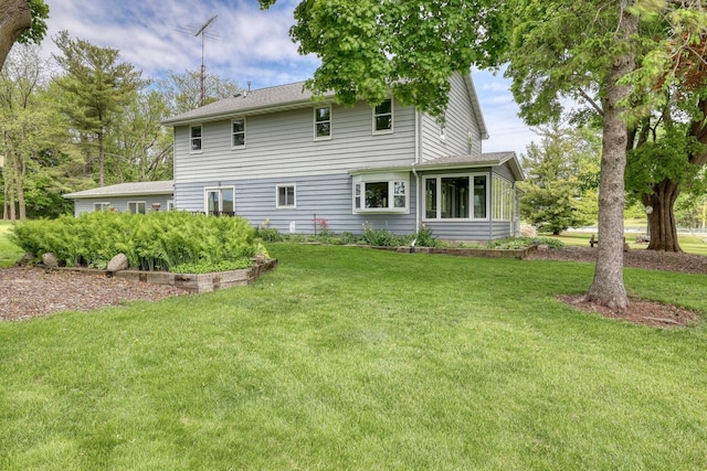W1041 County Road O, Oconomowoc, WI 53066 - rear view of property with a lawn and a sunroom